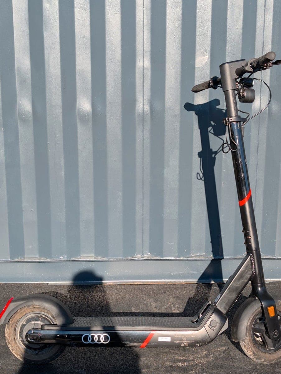 Audi Electric Kick Scooter powered by Egret Pro von der Seite, Audi-Ringe auf dem Trittbrett