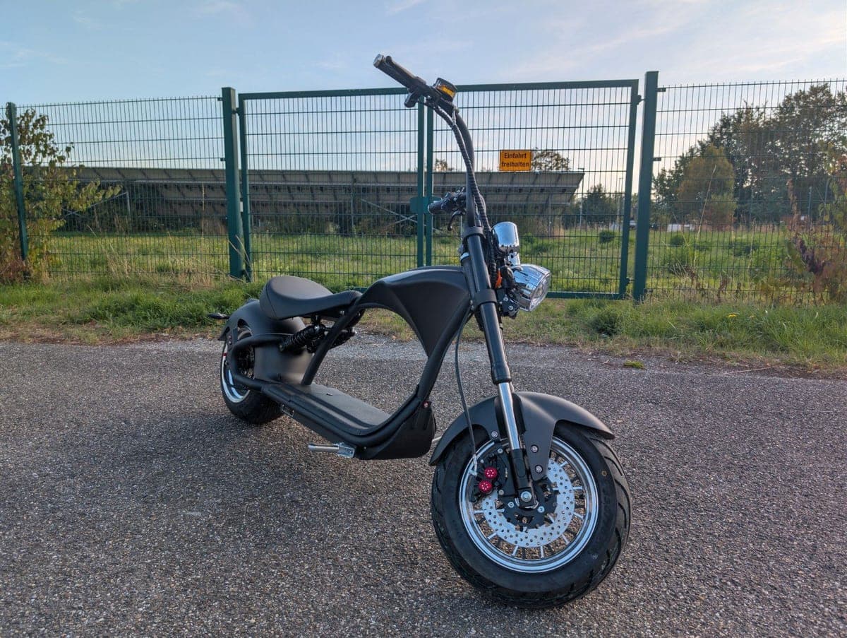Mangosteen M1-P E-Chopper schräg von vorn, mattschwarzer Rahmen mit Speichenfelgen und roten Bremssätteln