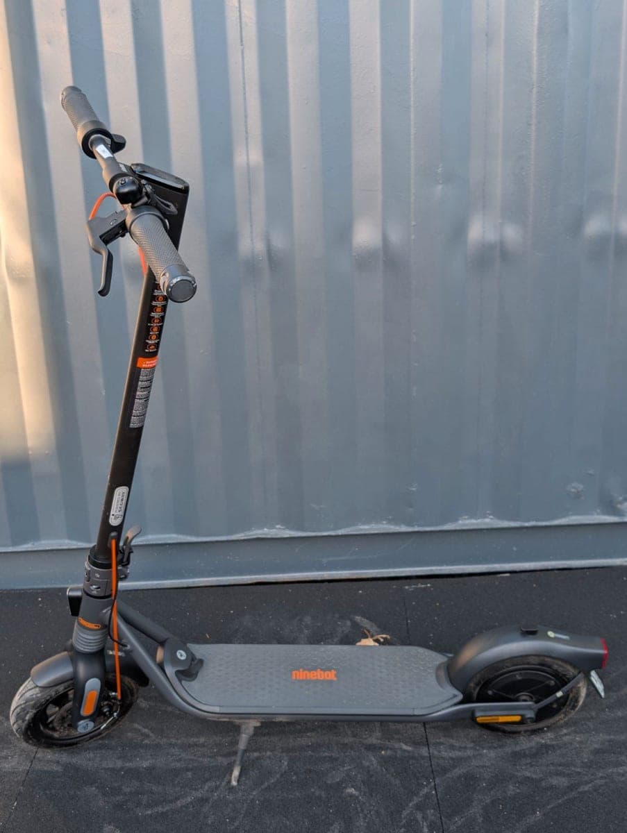 Segway Ninebot F2 Pro schräg von vorn mit orangefarbenem Bremszug an der Lenkstange
